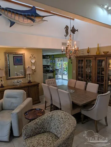 a living room with furniture a chandelier and a dining table
