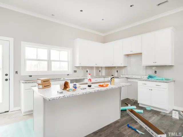 a kitchen with a sink a stove a window and cabinets