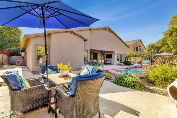 a view of a patio with a table and chairs under an umbrella