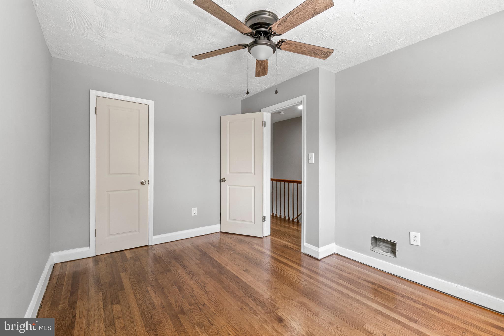 2214 Hawthorne Road Baltimore, MD 21220 - Photo 17 of 28 a view of a livingroom with wooden floor and a ceiling fan