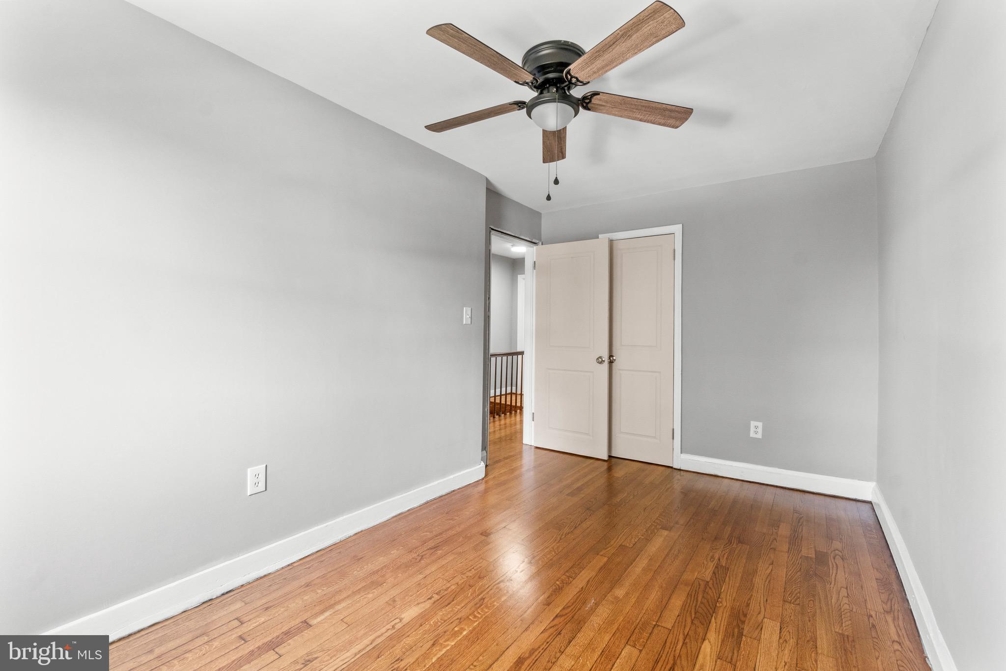 2214 Hawthorne Road Baltimore, MD 21220 - Photo 18 of 28 an empty room with wooden floor and ceiling fan