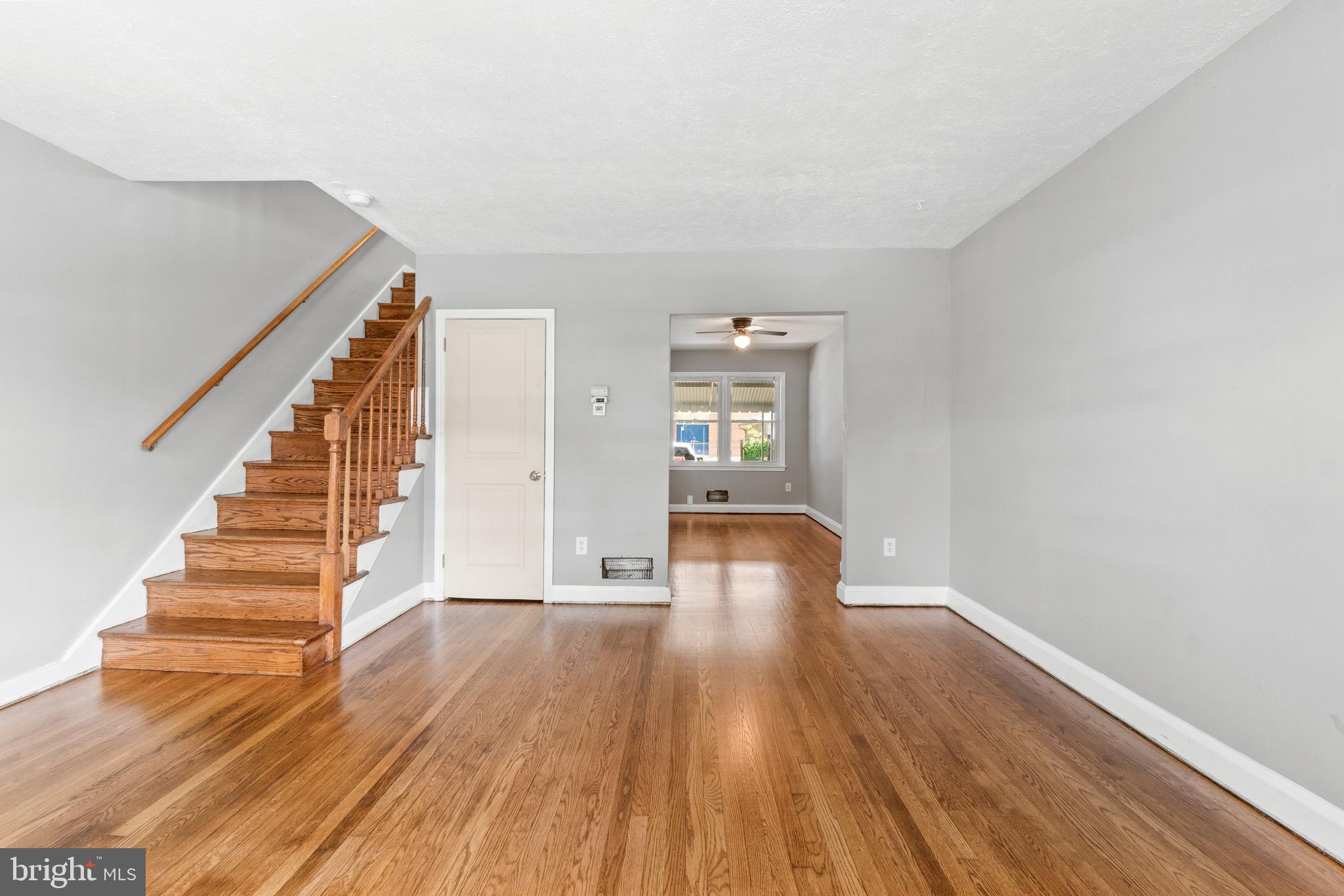 2214 Hawthorne Road Baltimore, MD 21220 - Photo 8 of 28 a view of an empty room with wooden floor and stairs