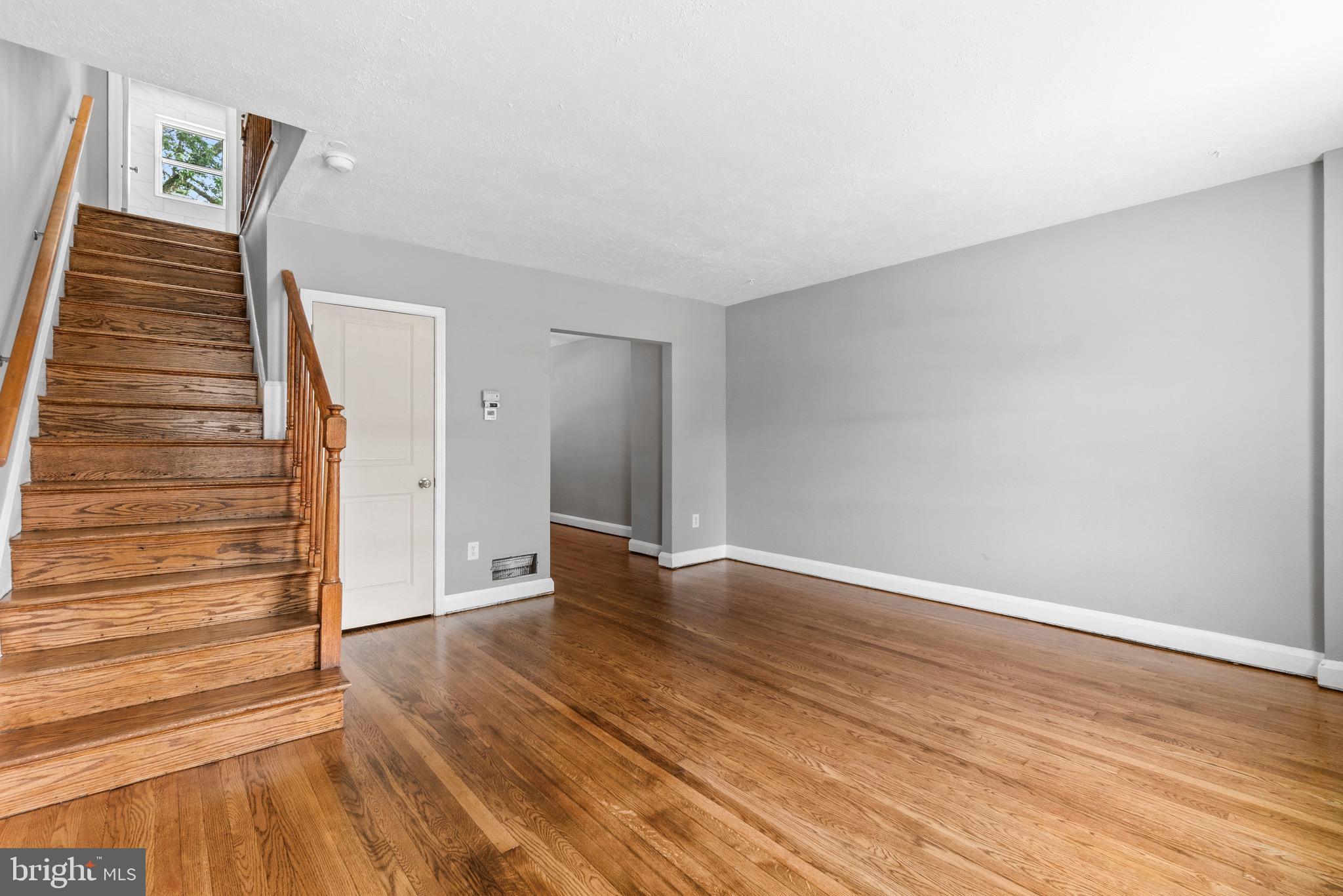 2214 Hawthorne Road Baltimore, MD 21220 - Photo 9 of 28 a view of an empty room with wooden floor and stairs