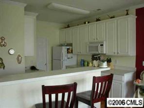 2341 Mirage Place Fort Mill, SC 29708 - Photo 6 of 8 a kitchen with stainless steel appliances kitchen island granite countertop a table chairs and a refrigerator