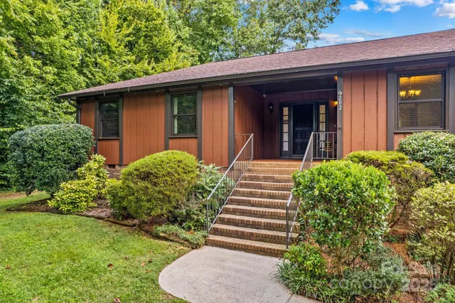 a view of a house with potted plants and a table and chairs