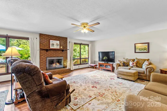 a living room with furniture a fireplace and a flat screen tv