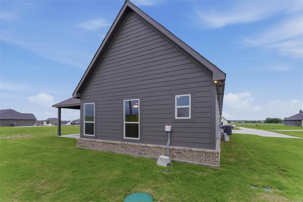 119 Hillview Trail Decatur, TX 76234 - Photo 29 of 30 Exterior featuring dark gray siding, a pitched roofline, and a brick skirt foundation