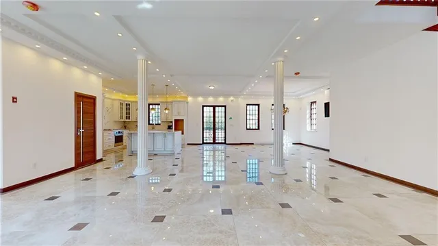 a large white kitchen with white cabinets and stainless steel appliances