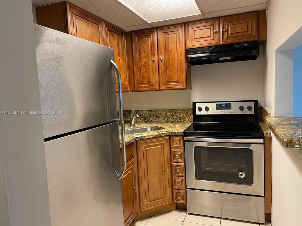 a white refrigerator freezer and a stove sitting inside of a kitchen