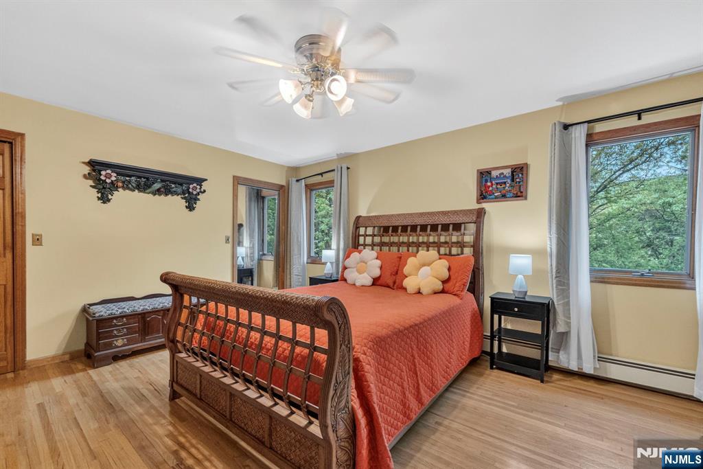 5110 Berkshire Valley Road Oak Ridge, NJ 07438 - Photo 29 of 49 a bedroom with a bed and a chandelier