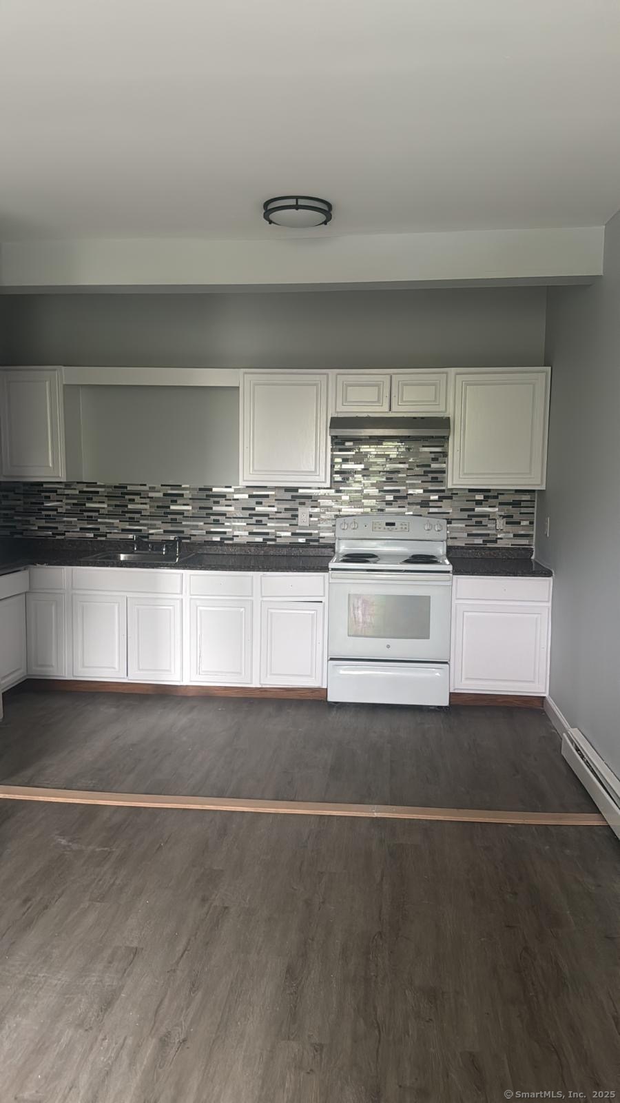 a kitchen with a stove and white cabinets