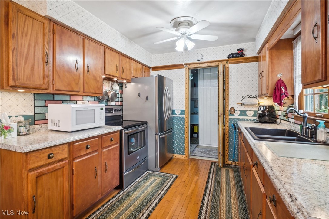 2820 Adams Road Kingsville, OH 44048 - Photo 22 of 34 Kitchen with light hardwood / wood-style flooring, sink, stainless steel appliances, and ceiling fan