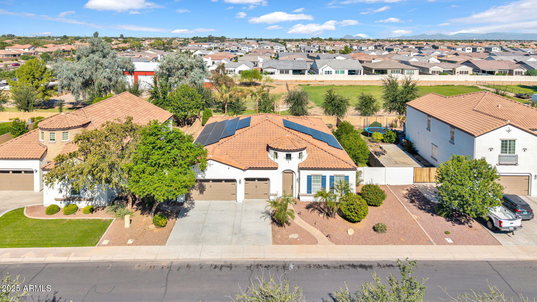 an aerial view of a house with a garden and mountain view in back