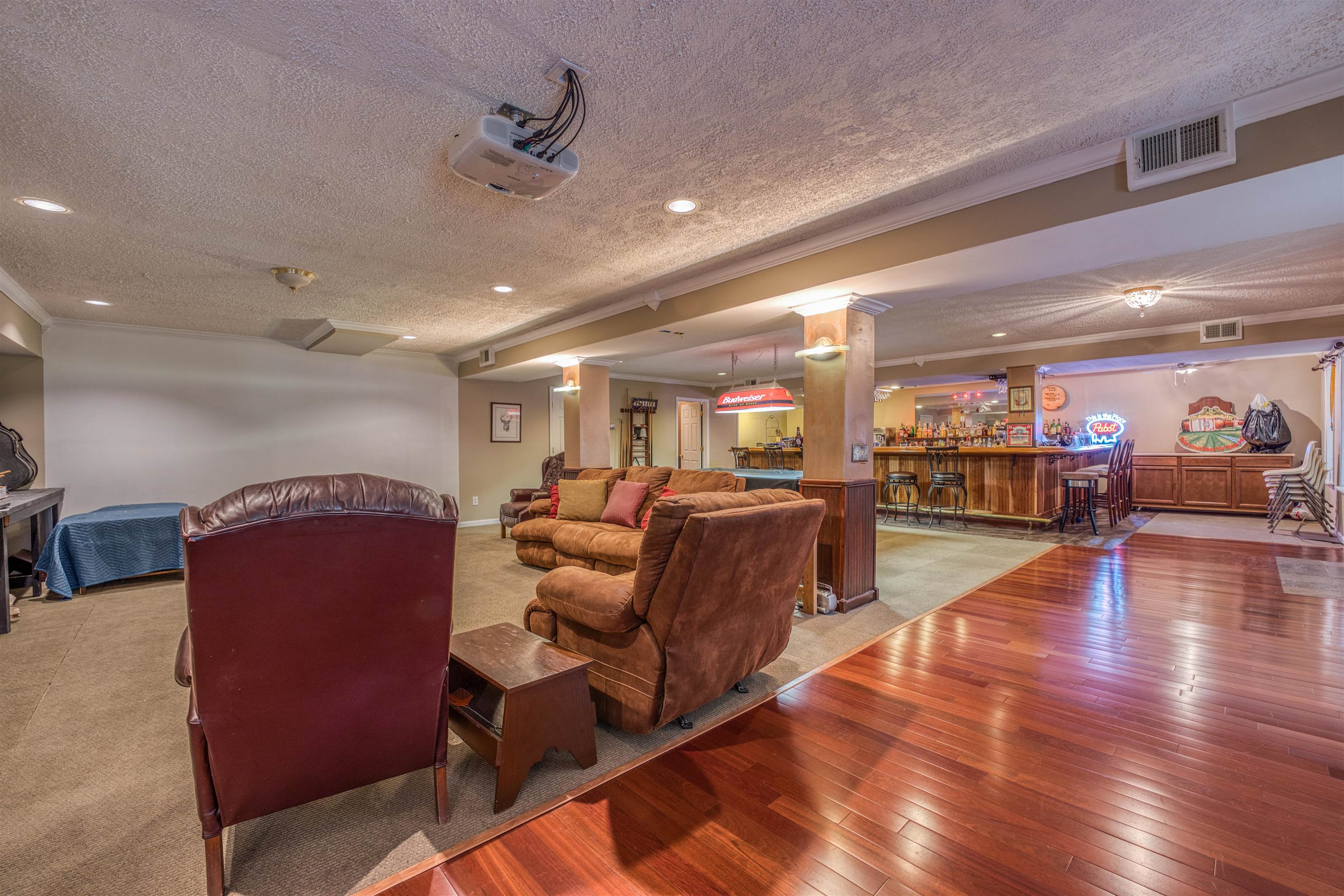 1470 Cherry Road Eads, TN 38028 - Photo 26 of 40 Home theater room featuring a textured ceiling, bar, hardwood / wood-style flooring, and ornate columns