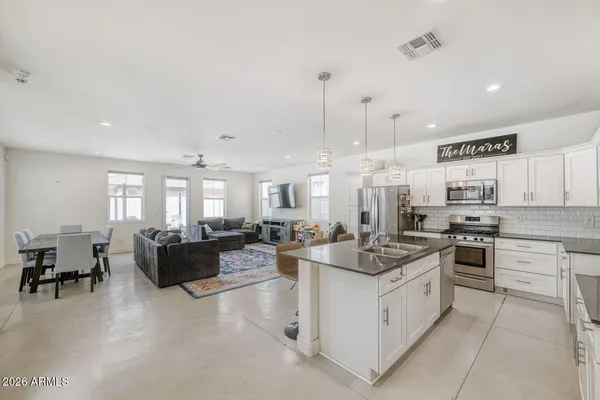 a open kitchen with stainless steel appliances kitchen island granite countertop a stove and a living room view
