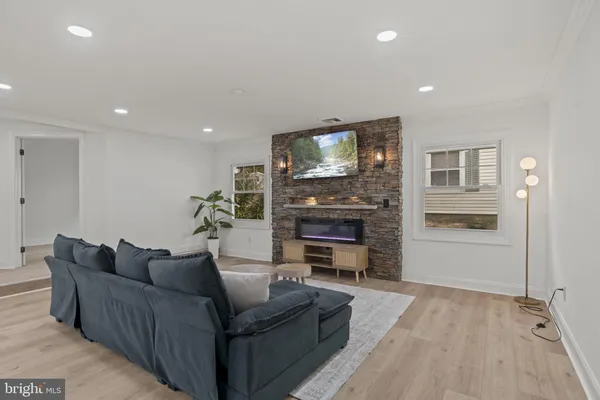 a living room with furniture a flat screen tv and a fireplace