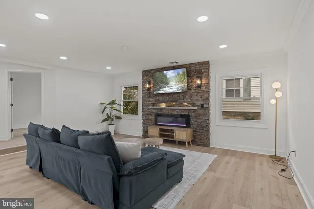 a living room with furniture a flat screen tv and a fireplace