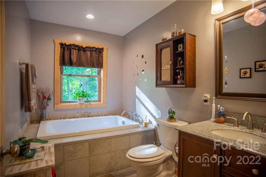 603 Wild Turkey Road Ferguson, NC 28624 - Photo 30 of 46 a bathroom with a granite countertop sink toilet and a mirror