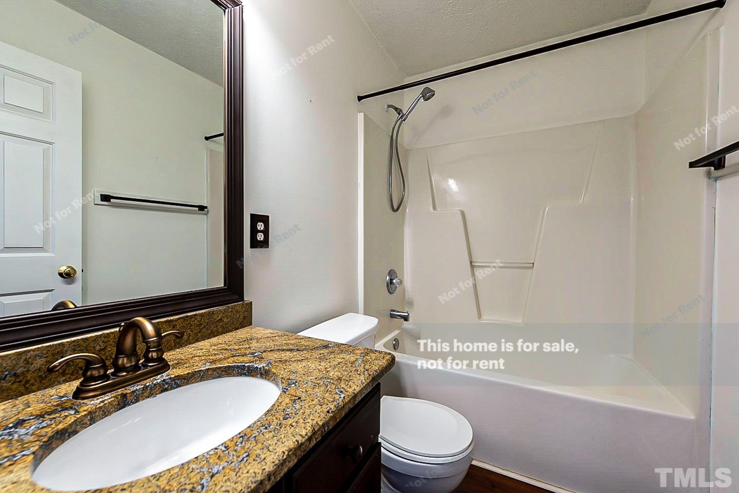 3104 Mango Drive Raleigh, NC 27610 - Photo 14 of 18 a bathroom with a granite countertop sink toilet mirror and a bathtub