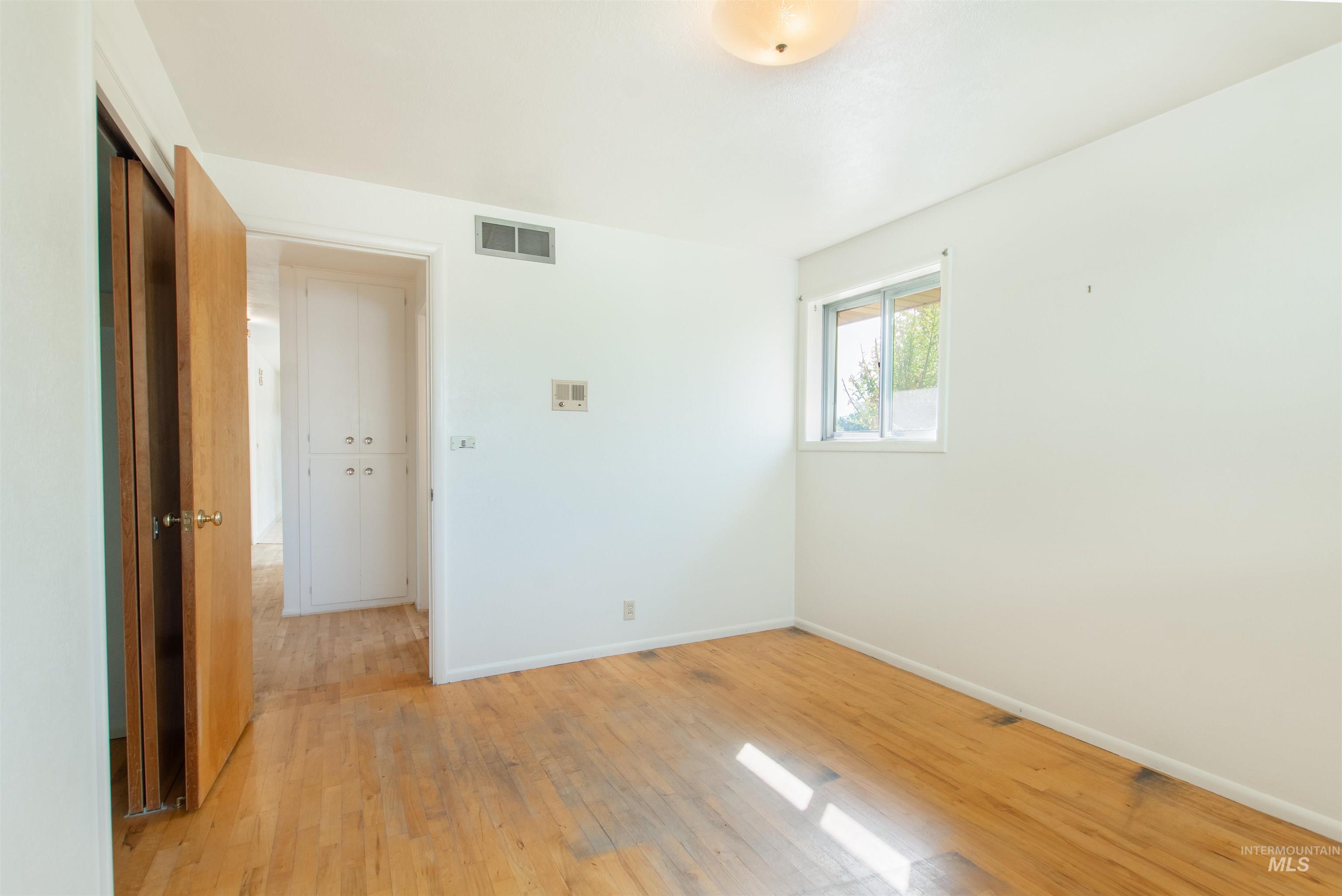 2716 North Redway Road Boise, ID 83704 - Photo 21 of 36 Hardwood flooring, white painted walls, window with natural light, built-in storage, and ceiling-mounted light fixture