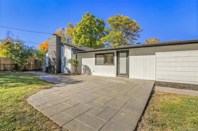 a view of a house with a yard and potted plants