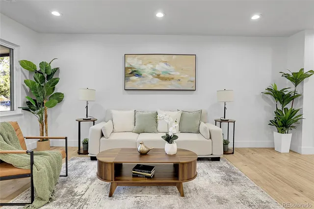 a living room with furniture a potted plant and a table