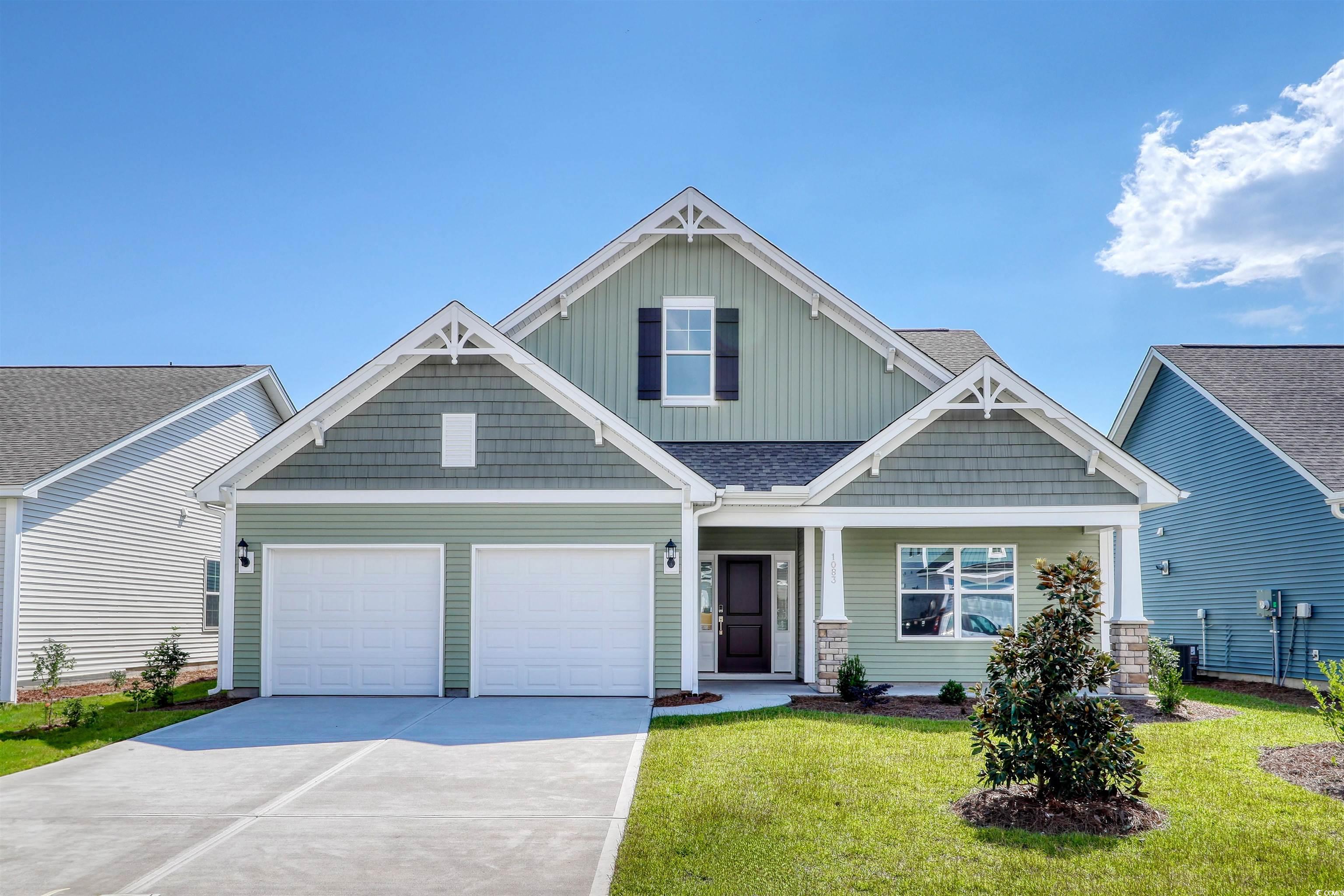 Craftsman-style house featuring board and batten siding, covered porch, concrete driveway, a front lawn, and an attached garage
