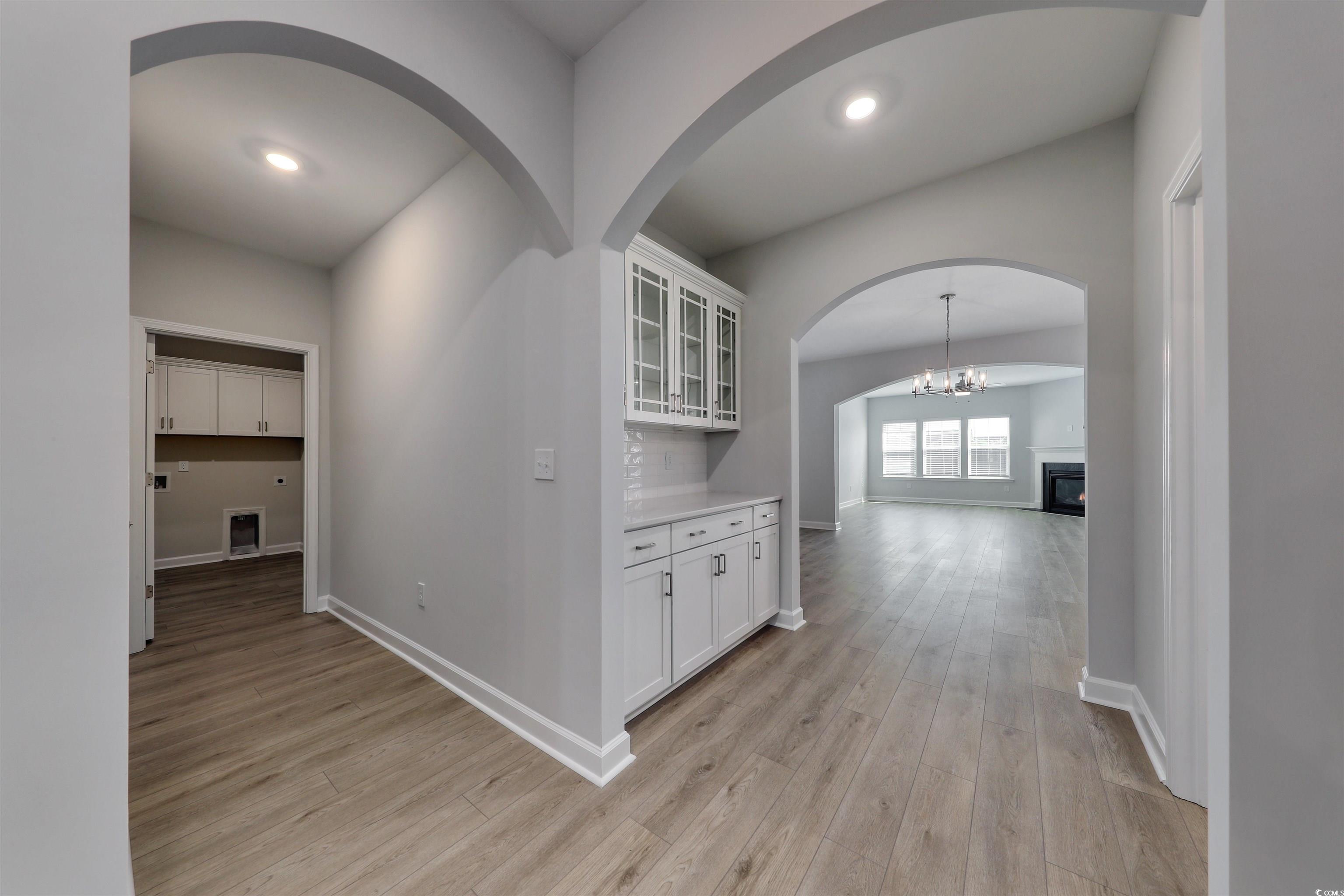 1083 Laconic Drive Myrtle Beach, SC 29588 - Photo 10 of 40 Hall featuring a chandelier, light wood-style floors, arched walkways, and recessed lighting