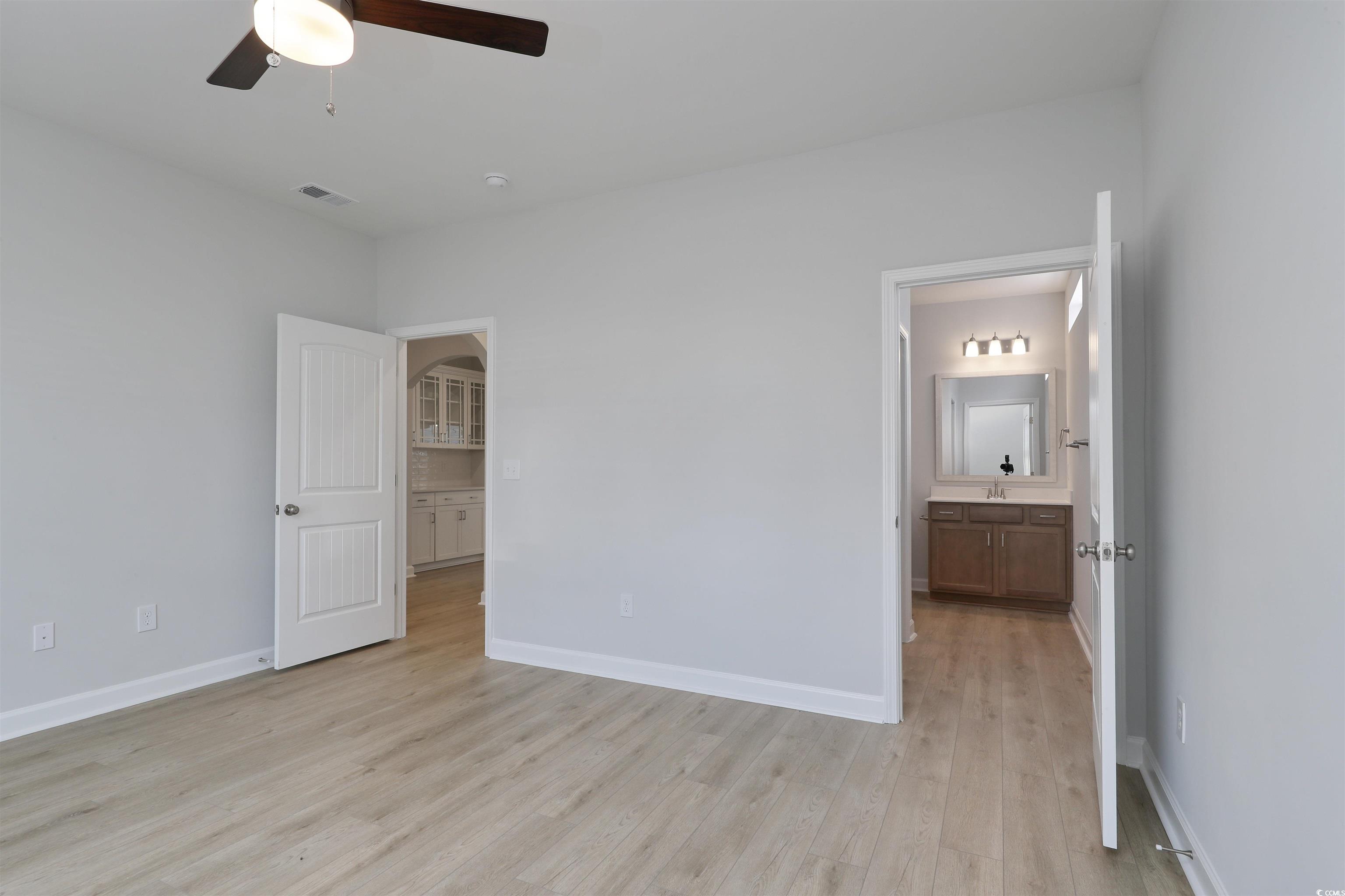1083 Laconic Drive Myrtle Beach, SC 29588 - Photo 13 of 40 Unfurnished bedroom featuring light wood-style floors, connected bathroom, and ceiling fan