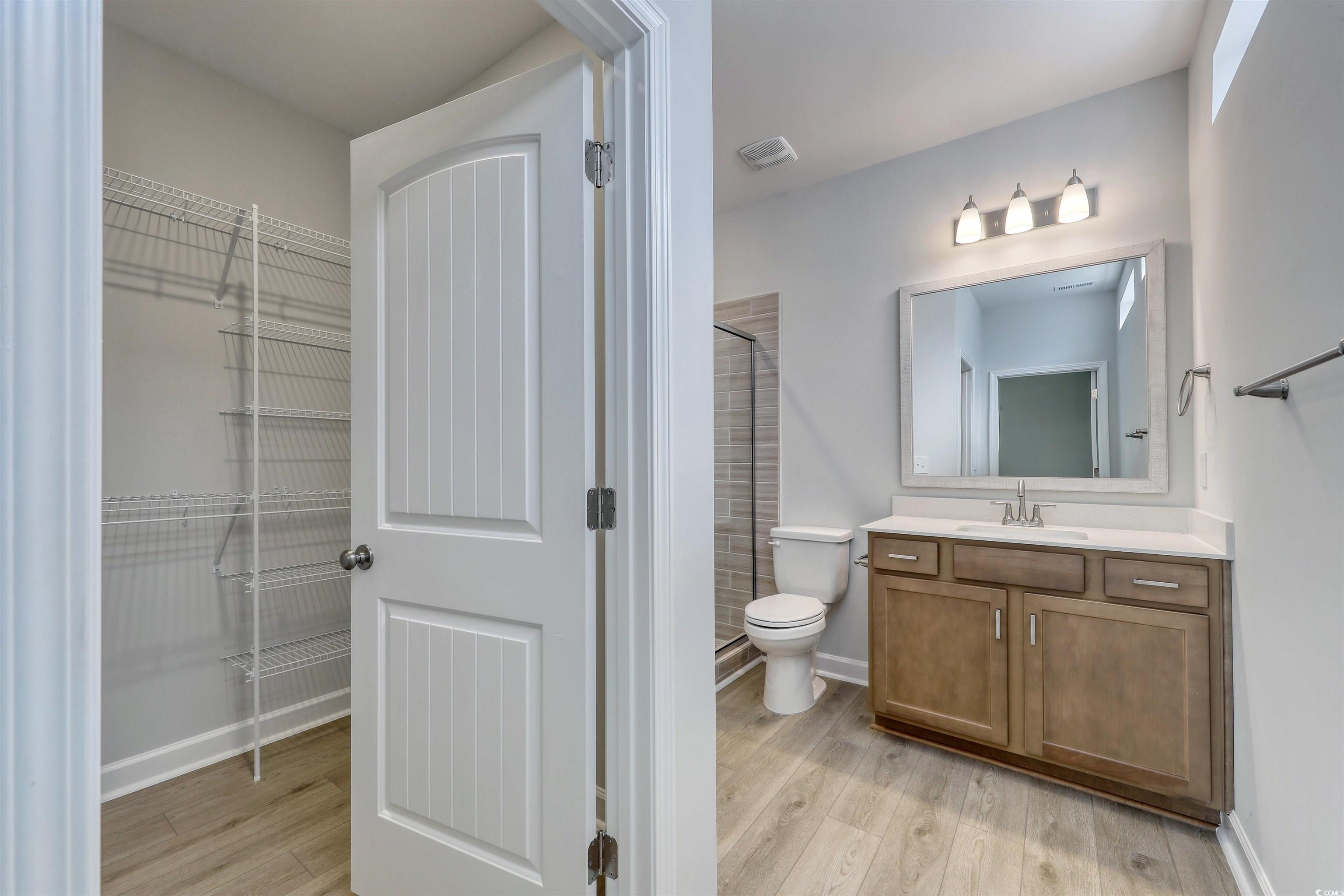 1083 Laconic Drive Myrtle Beach, SC 29588 - Photo 15 of 40 Full bath with a stall shower, vanity, light wood finished floors, and a walk in closet