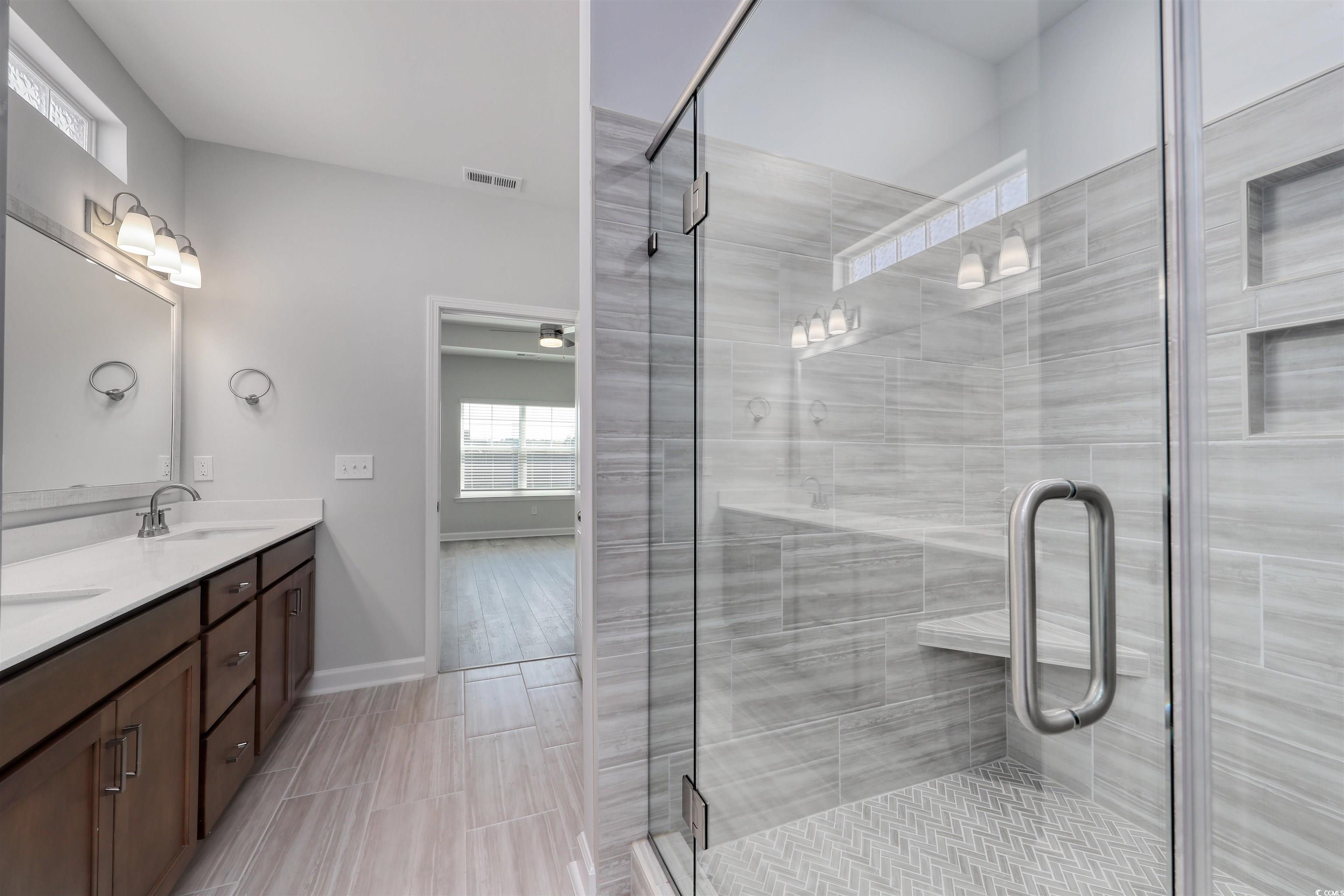 1083 Laconic Drive Myrtle Beach, SC 29588 - Photo 22 of 40 Bathroom featuring plenty of natural light, double vanity, and a shower stall