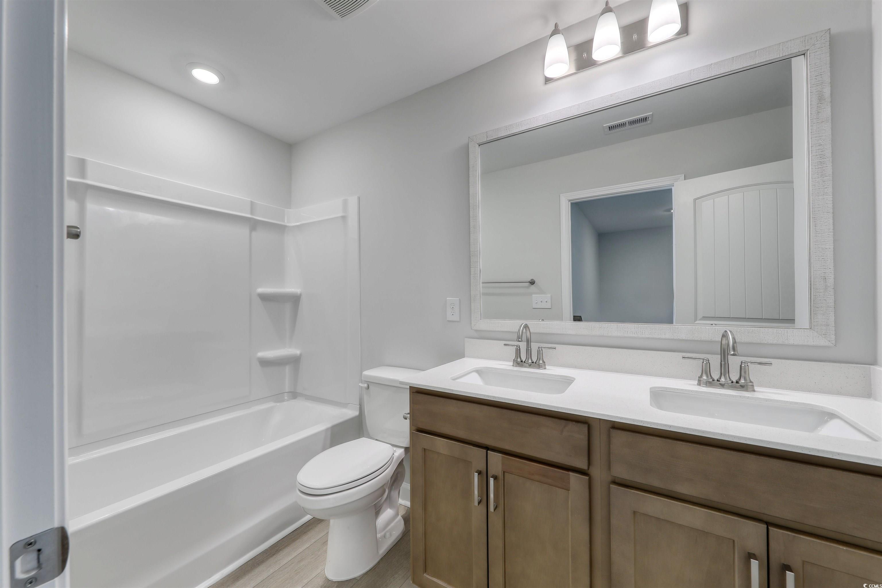 1083 Laconic Drive Myrtle Beach, SC 29588 - Photo 27 of 40 Full bath featuring double vanity, shower / bath combination, light wood finished floors, and recessed lighting