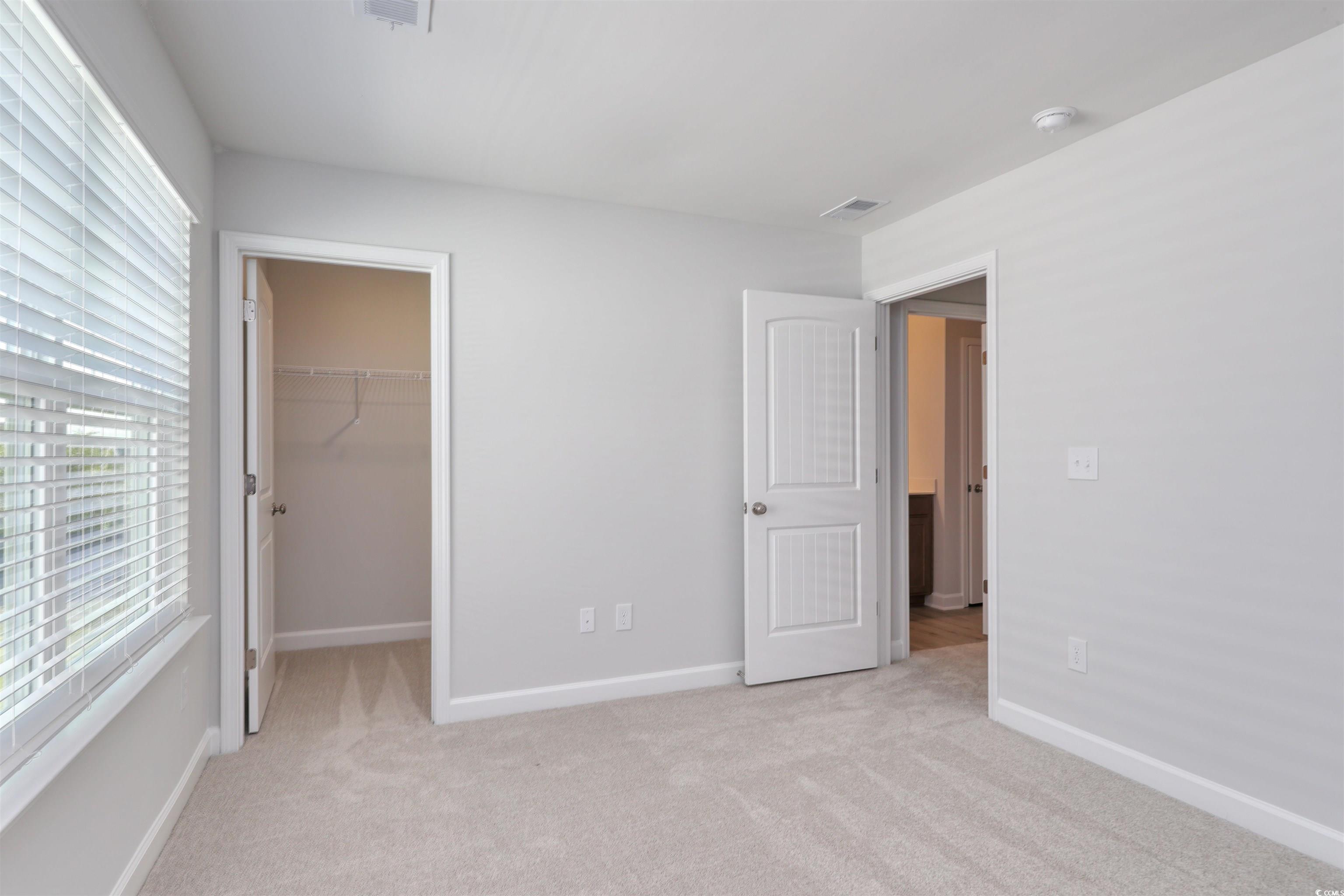 1083 Laconic Drive Myrtle Beach, SC 29588 - Photo 29 of 40 Unfurnished bedroom featuring light carpet and a walk in closet
