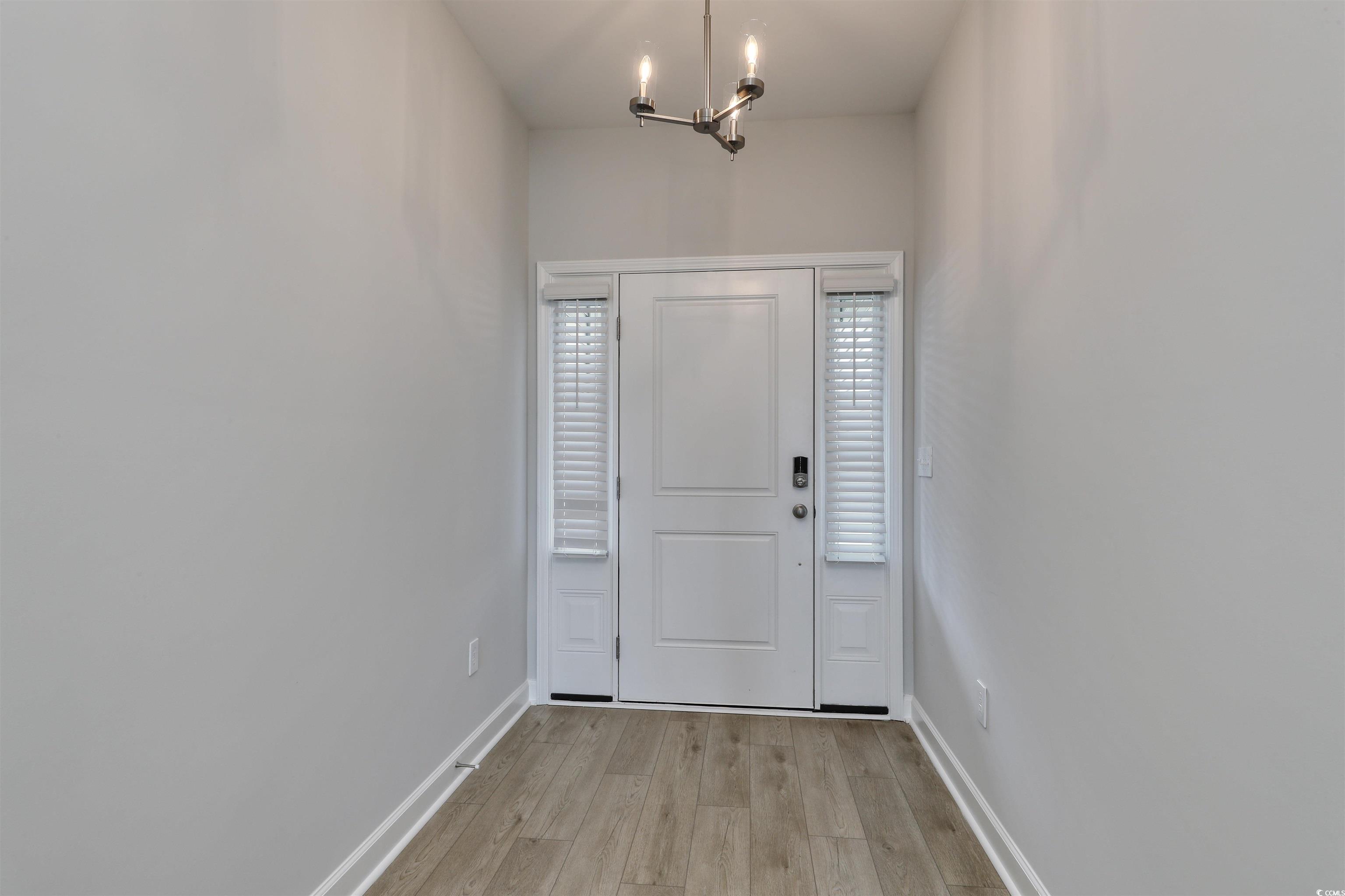 1083 Laconic Drive Myrtle Beach, SC 29588 - Photo 3 of 40 Foyer entrance featuring light wood-style flooring and a chandelier