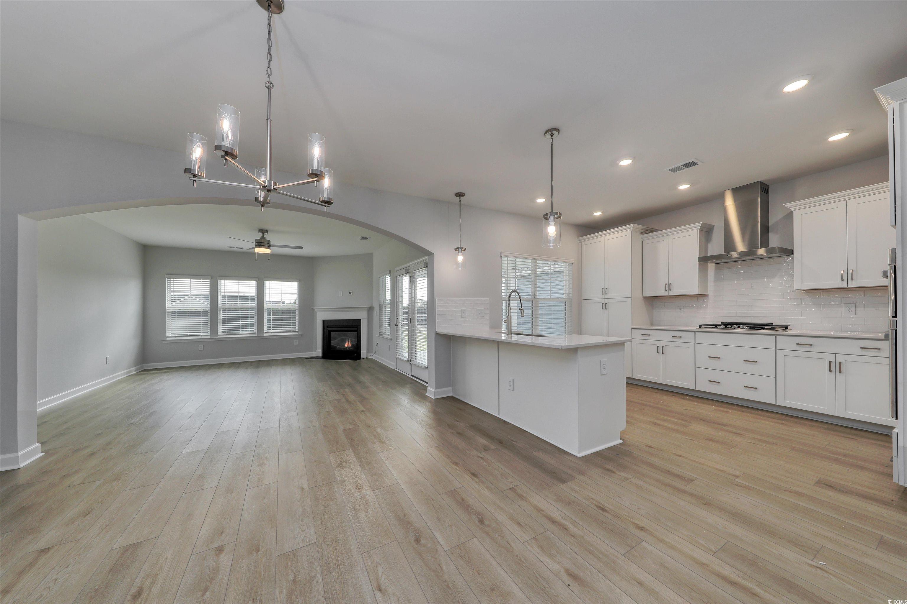 1083 Laconic Drive Myrtle Beach, SC 29588 - Photo 40 of 40 Kitchen with open floor plan, a chandelier, decorative backsplash, white cabinets, and decorative light fixtures