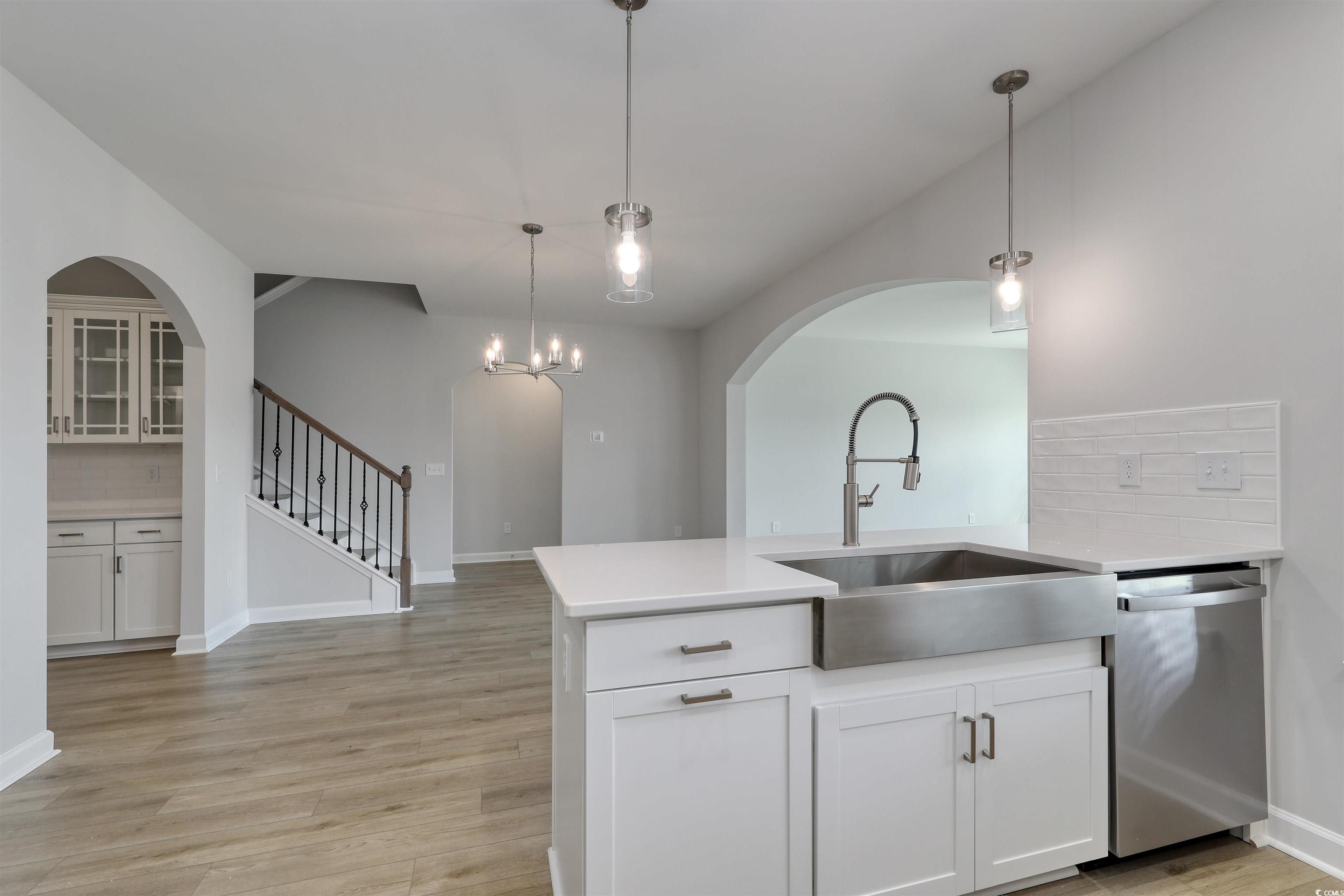 1083 Laconic Drive Myrtle Beach, SC 29588 - Photo 8 of 40 Kitchen with backsplash, a peninsula, light wood-style flooring, pendant lighting, and dishwasher