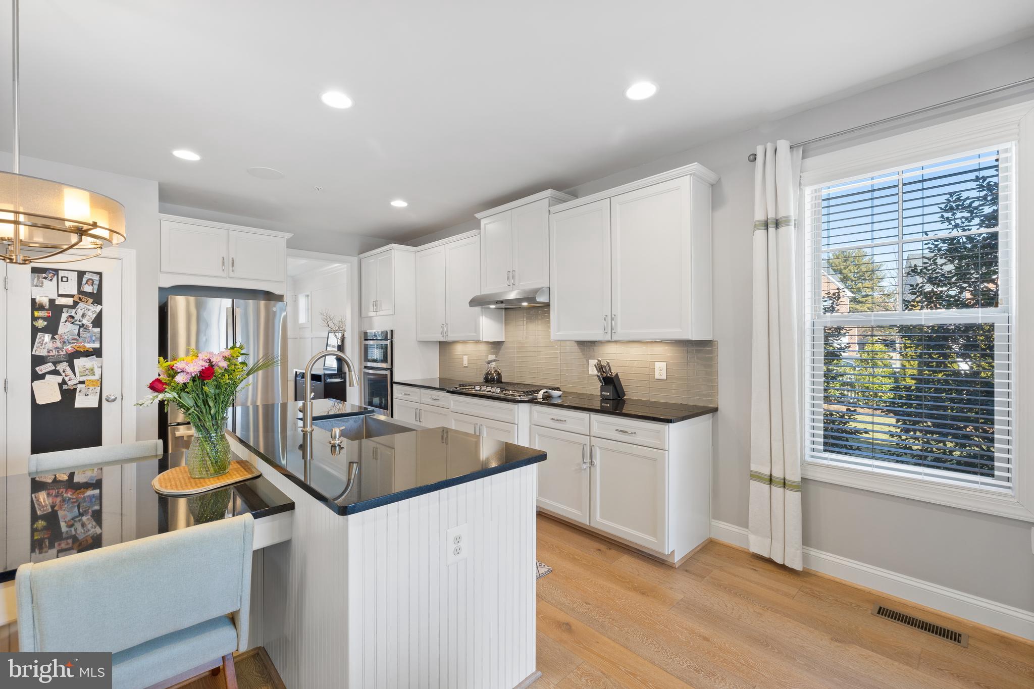 13410 Redspire Drive Silver Spring, MD 20906 - Photo 11 of 43 a kitchen with stainless steel appliances granite countertop a stove top oven a sink dishwasher a dining table and chairs with wooden floor