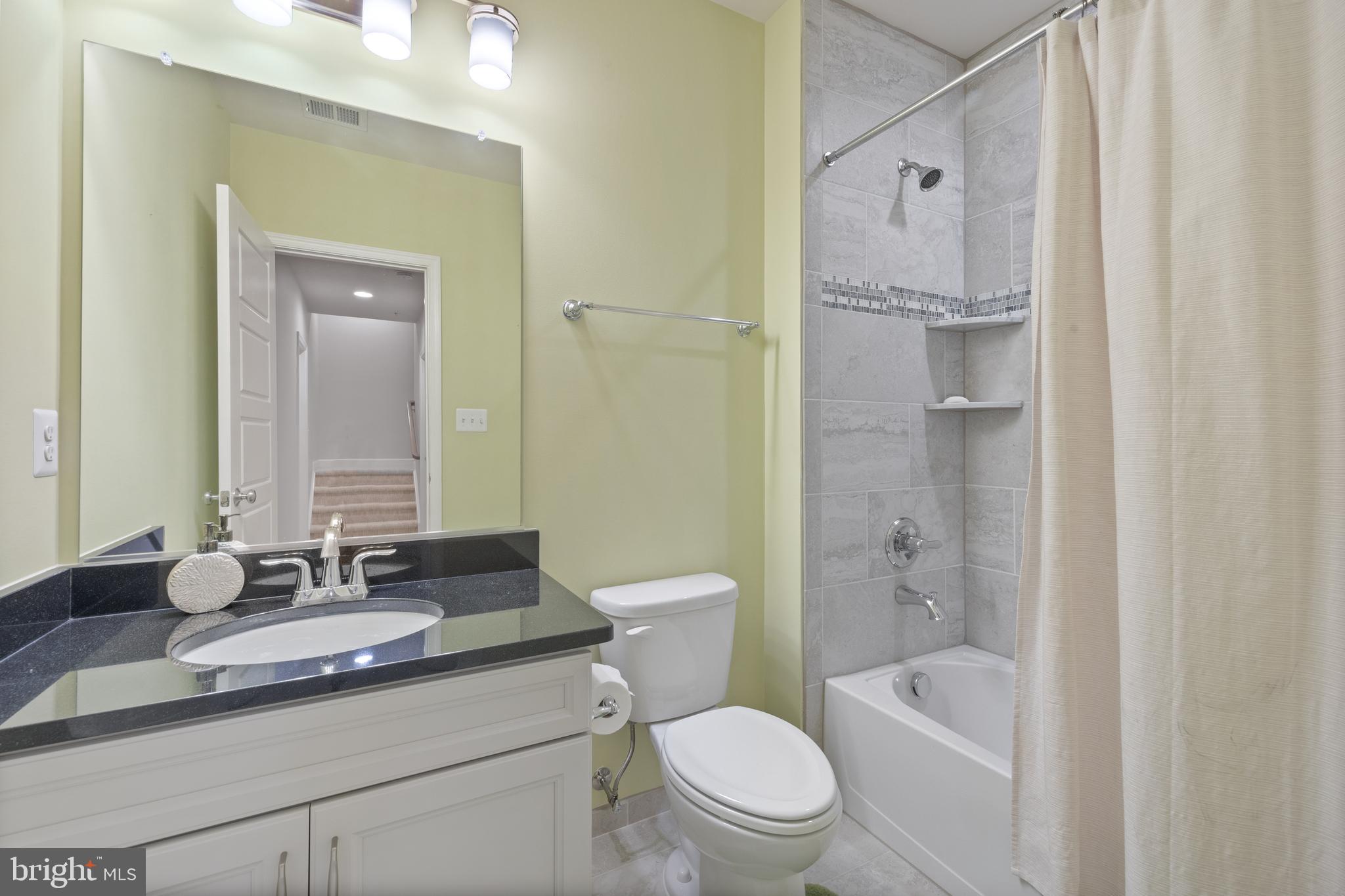 13410 Redspire Drive Silver Spring, MD 20906 - Photo 29 of 43 a bathroom with a granite countertop sink a toilet and a mirror