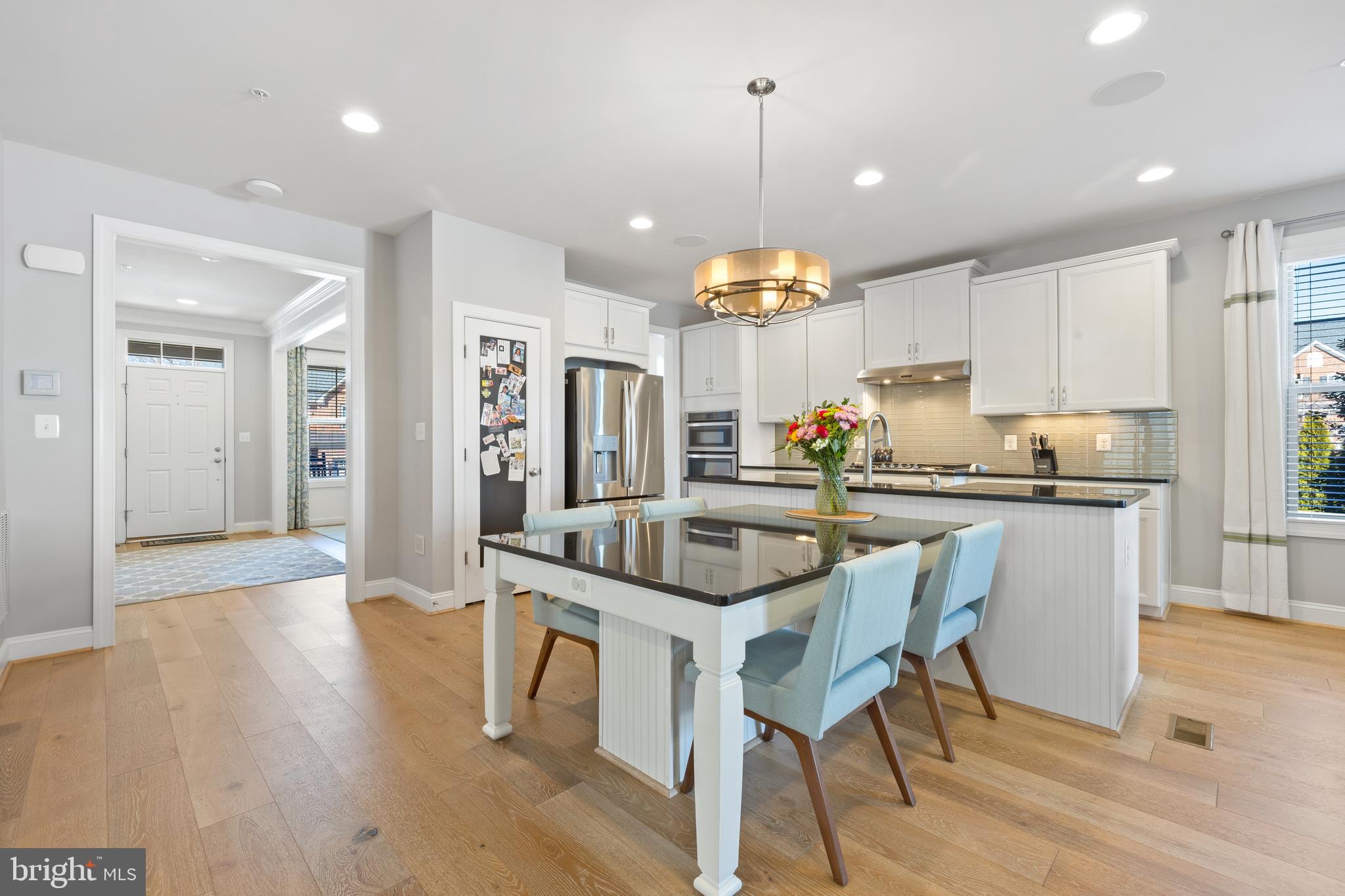 13410 Redspire Drive Silver Spring, MD 20906 - Photo 6 of 43 a kitchen with stainless steel appliances kitchen island granite countertop a table chairs and a refrigerator