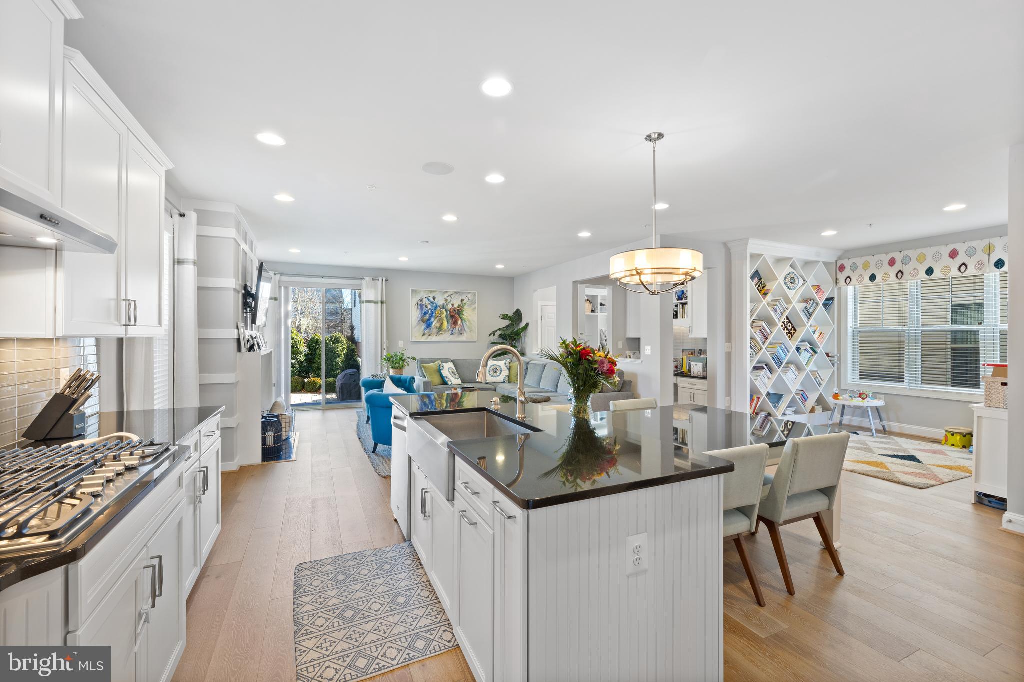 13410 Redspire Drive Silver Spring, MD 20906 - Photo 7 of 43 a kitchen with stainless steel appliances kitchen island granite countertop a stove a refrigerator a oven a dining table and chairs with wooden floor