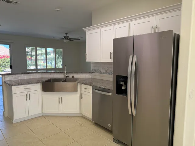 a kitchen with granite countertop white cabinets and stainless steel appliances