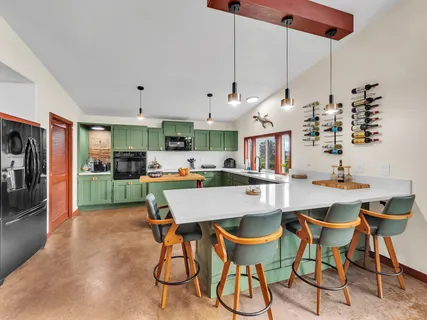 a kitchen with stainless steel appliances kitchen island a table and chairs in it