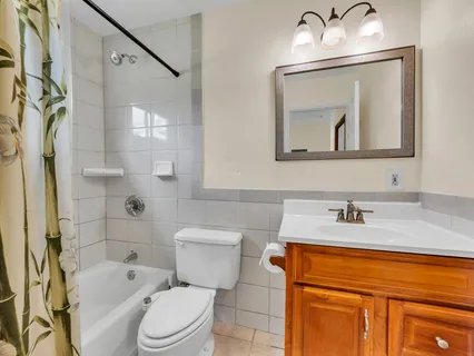 a bathroom with a granite countertop toilet sink and mirror