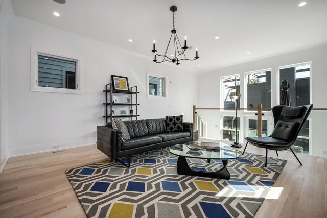 a living room with furniture a wooden floor and a chandelier