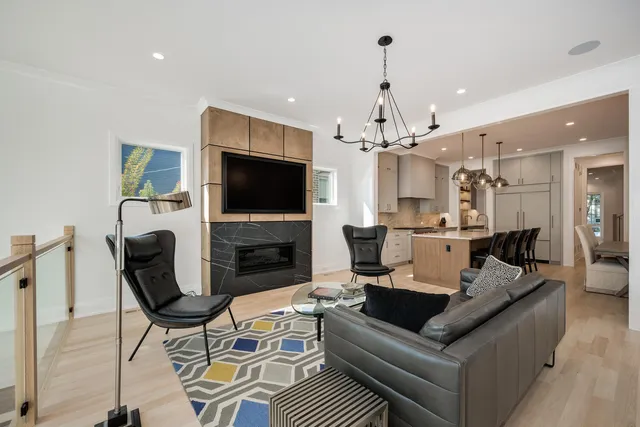 a living room with furniture a fireplace and a chandelier