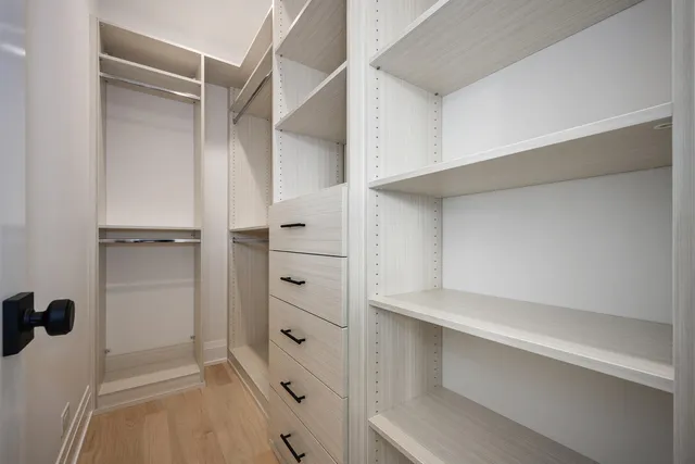 a view of walk in closet with empty racks