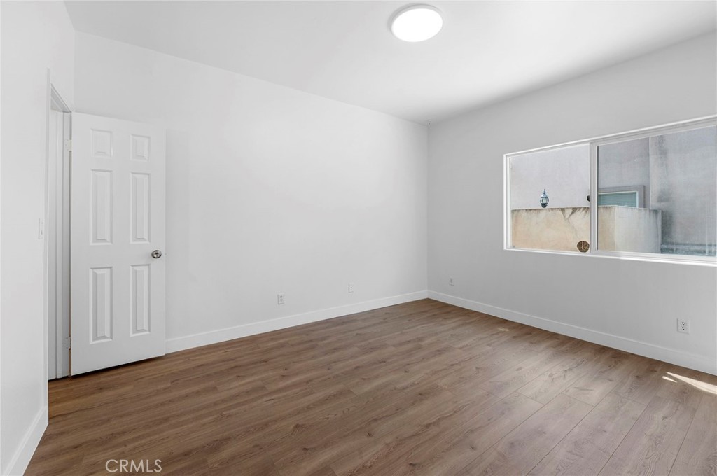 11552 Lower Azusa Road El Monte, CA 91732 - Photo 11 of 41 a view of an empty room with wooden floor and a window