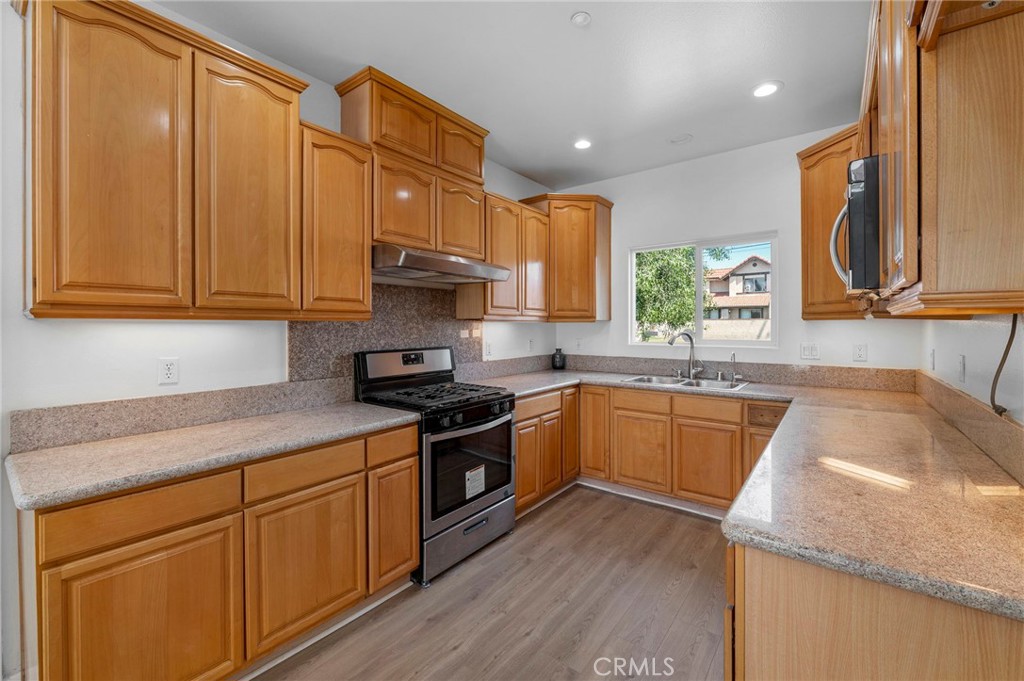 11552 Lower Azusa Road El Monte, CA 91732 - Photo 17 of 41 a kitchen with stainless steel appliances granite countertop wooden cabinets a stove a sink and dishwasher with wooden floor