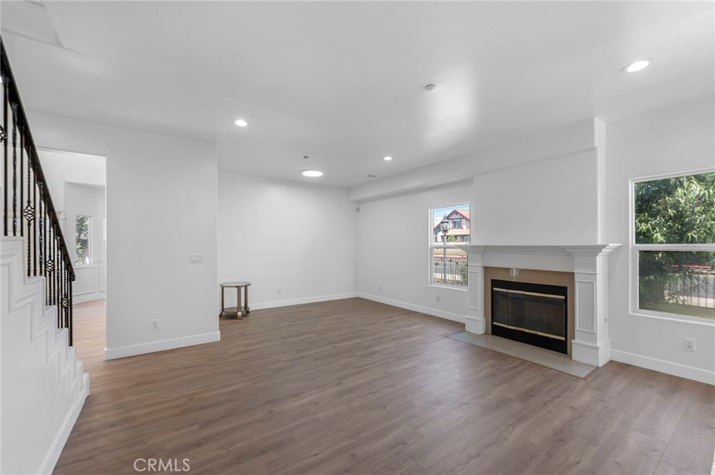 11552 Lower Azusa Road El Monte, CA 91732 - Photo 7 of 41 an empty room with wooden floor fireplace and windows