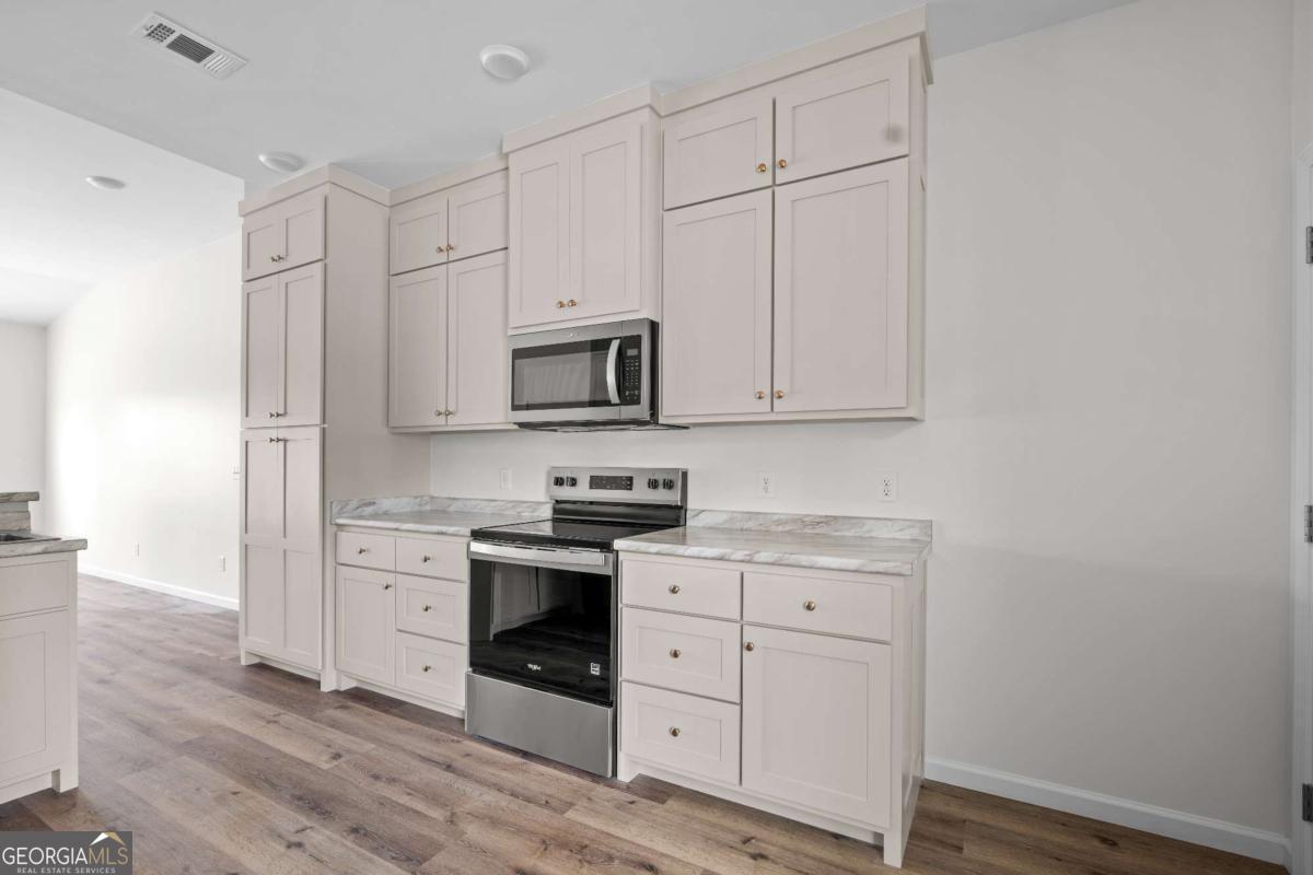 96 Beech Road Hazlehurst, GA 31539 - Photo 16 of 32 a kitchen with white cabinets stainless steel appliances and sink